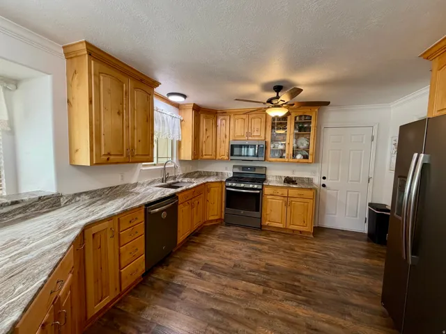 Kitchen featuring wood cabinetry, wood-finish flooring, and light-toned countertops