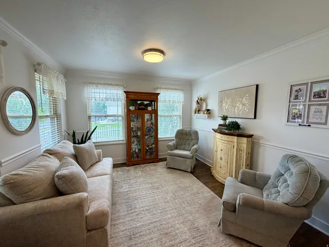 Bright room featuring crown molding, chair rail molding, and multiple windows with blinds