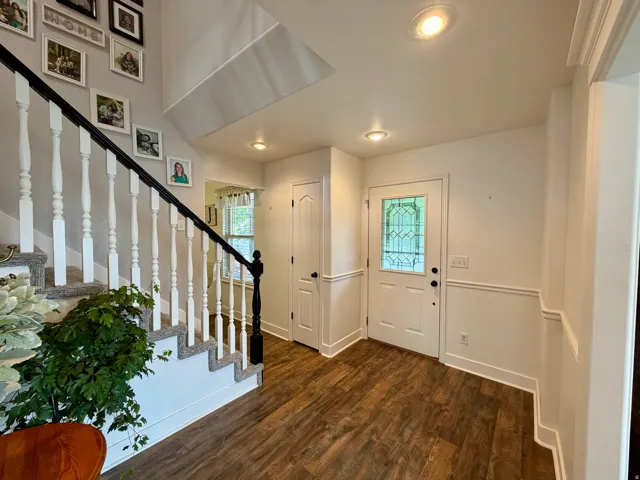 Entryway featuring wood-finish flooring, white wainscoting, and recessed lighting