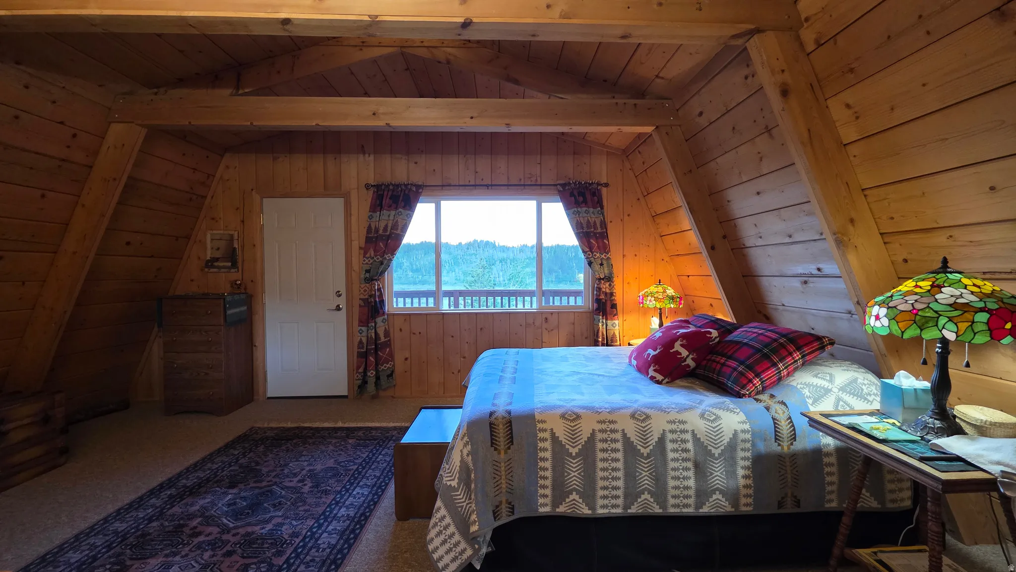 Wood-paneled room featuring exposed ceiling beams and sloped architectural details