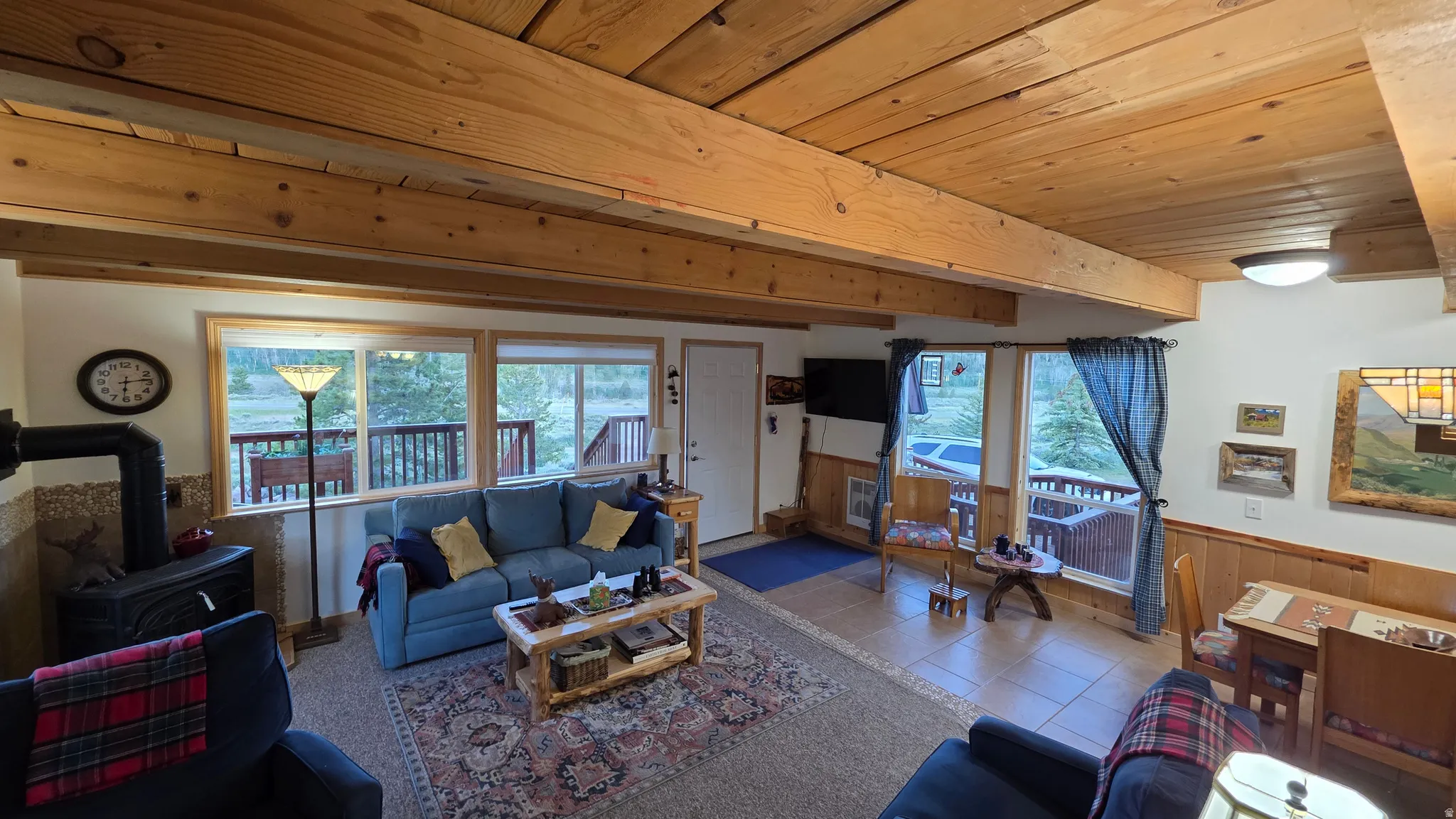 Living area with exposed wood beam ceiling and wood planking