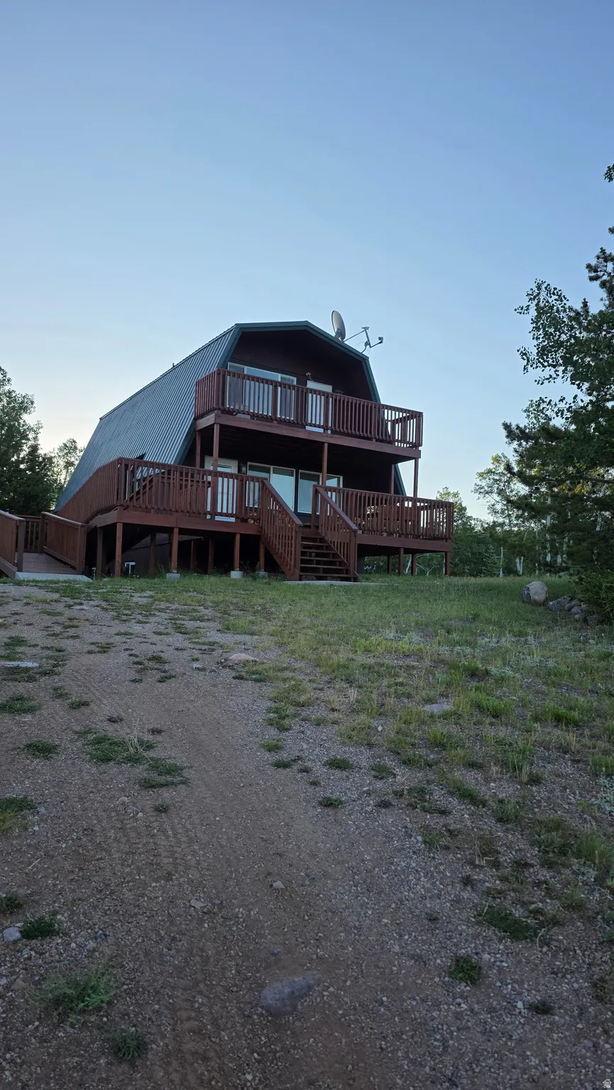 Two-story residence featuring a gambrel roof and dark-stained wood siding