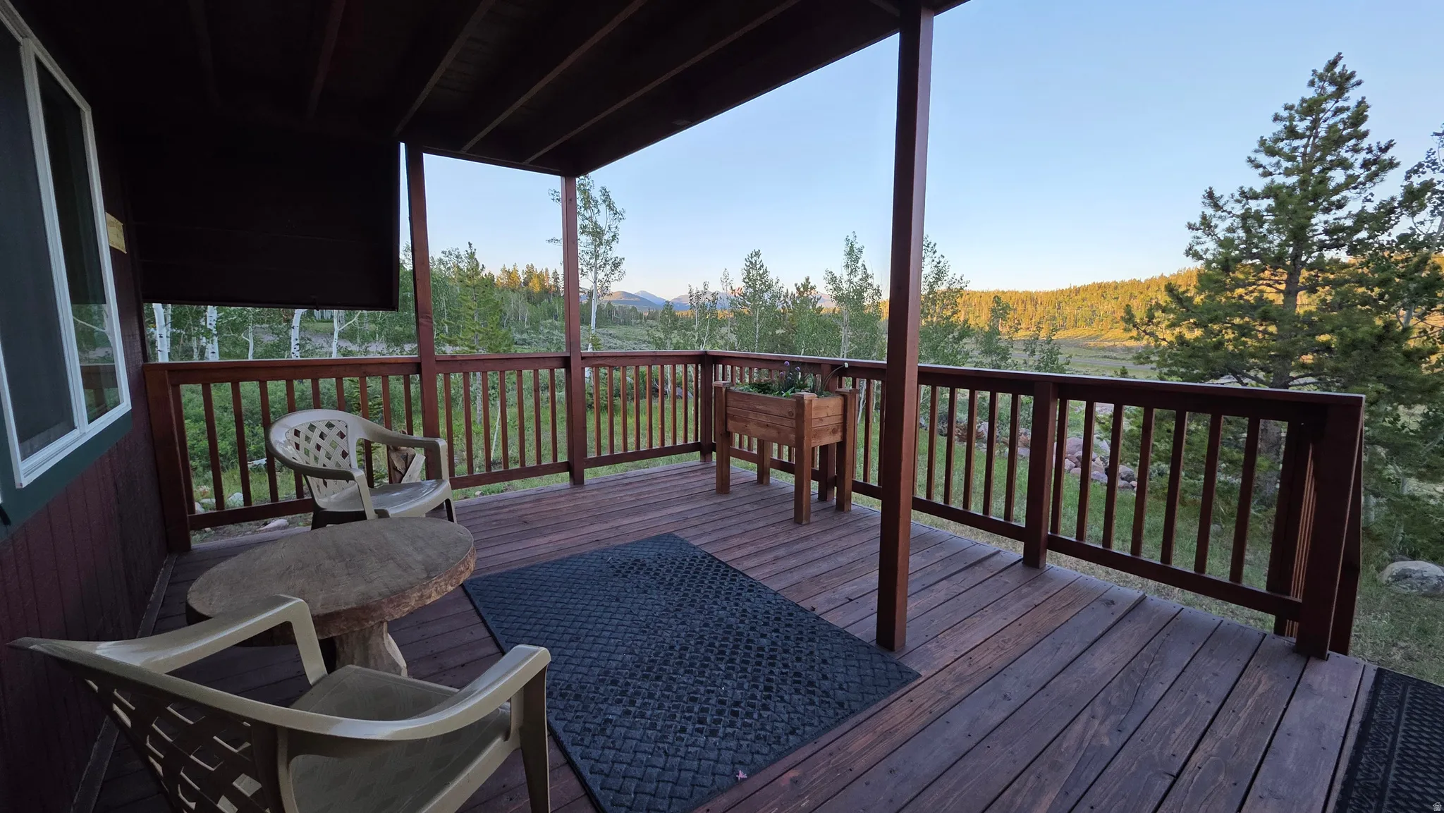 Covered wood deck with dark stained railing and posts