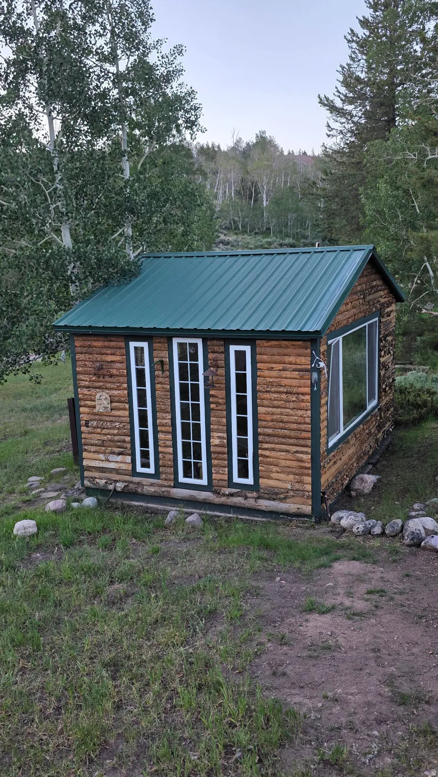 Log cabin exterior with a green metal roof