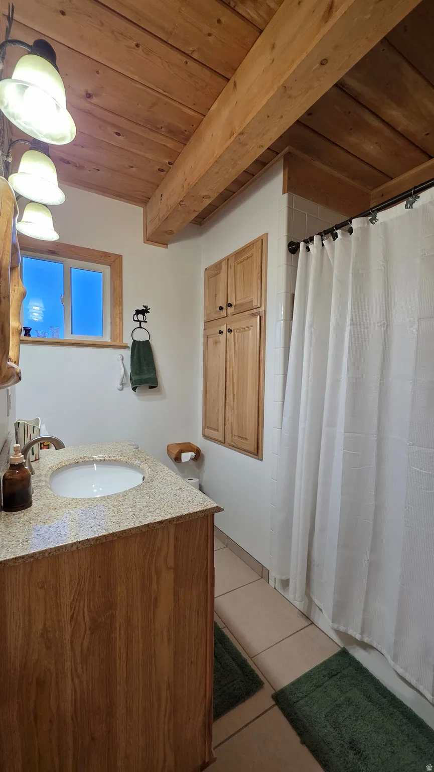 Bathroom featuring a light wood-finish vanity with an undermount sink and a speckled countertop