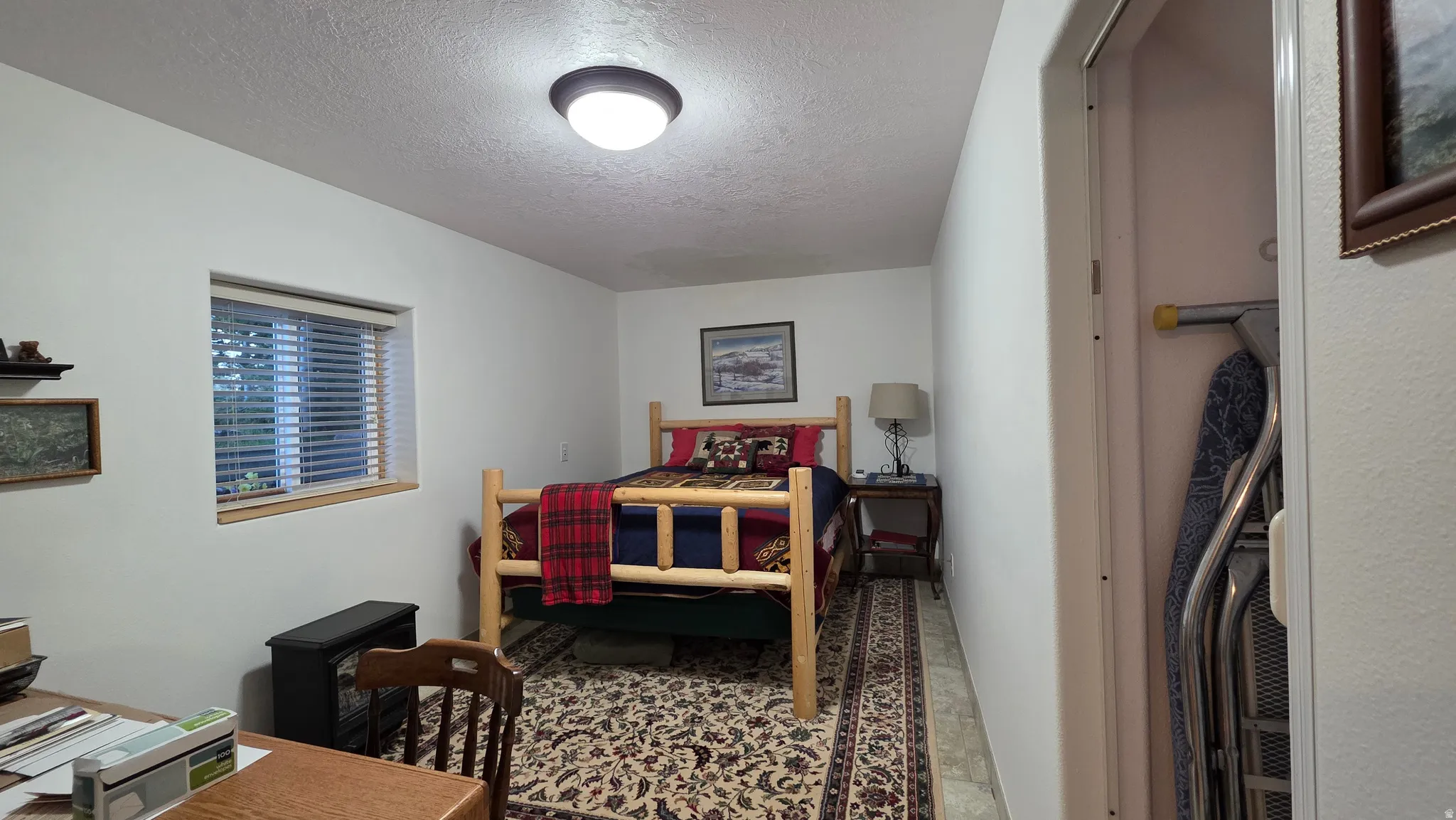 Room with a window featuring horizontal blinds and a wood sill