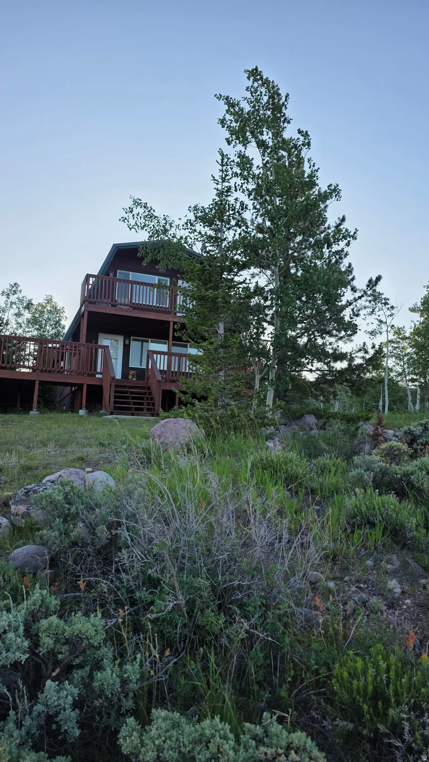 Multi-level dwelling with a dark exterior, featuring extensive decking with wooden railings