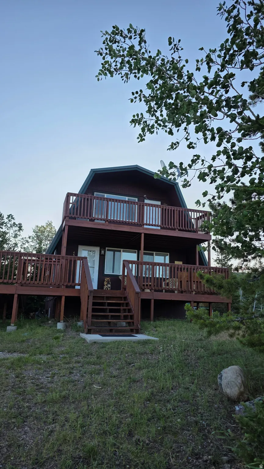Two-story gambrel roof residence featuring a dark wood exterior