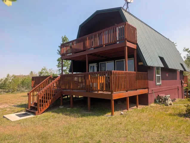 Barn-style residence featuring a metal roof and red siding