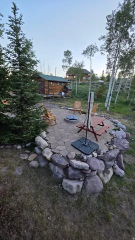 Paved patio area featuring a stone fire pit and a stone retaining wall
