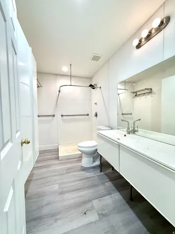 Contemporary bathroom featuring an expansive floating vanity with an integrated sink and a large mirror