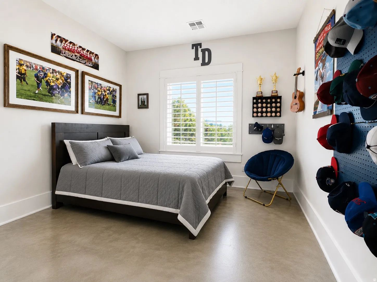 Bedroom featuring light-toned flooring, white walls, and a window with white louvered shutters