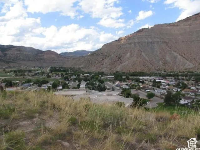 Expansive mountain landscape featuring a valley town with residential structures and established infrastructure