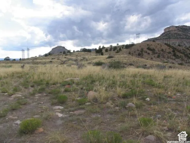Expansive natural landscape featuring rolling hills and distant elevated terrain