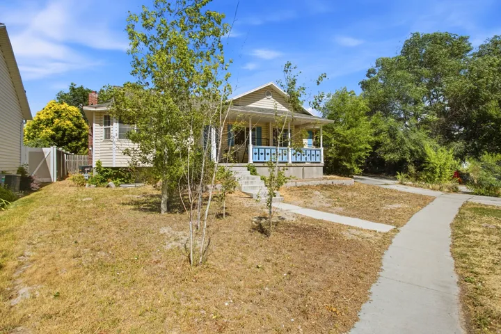 Property exterior featuring light-colored siding and a covered front porch with blue railing