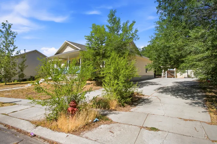 Single-story property with light yellow siding and a covered front porch featuring white columns