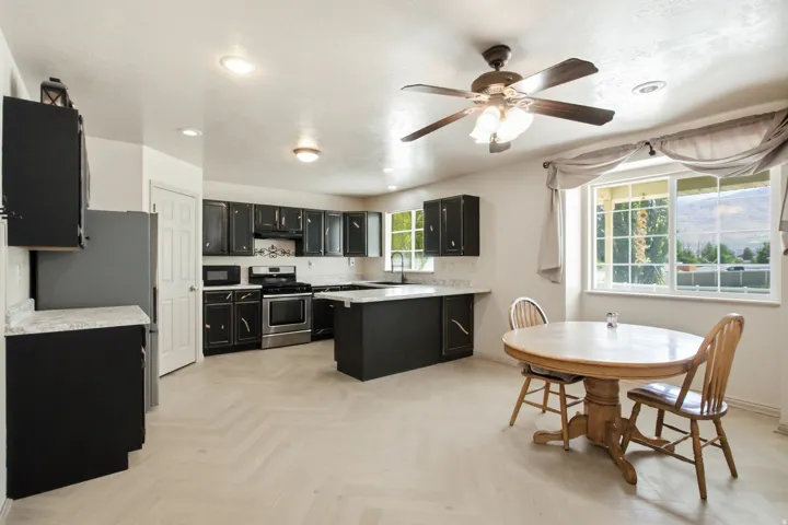 Kitchen area featuring light wood-finish flooring, dark cabinetry, and light countertops