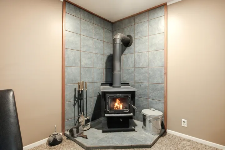 Corner wood-burning stove featuring a black finish and visible piping