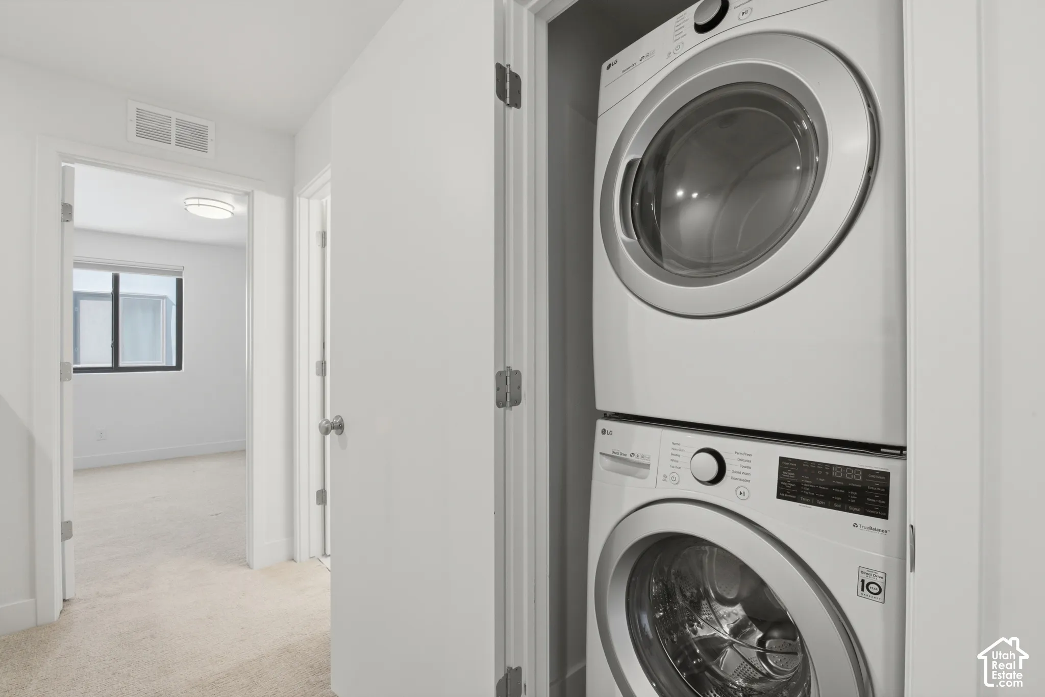 Dedicated laundry closet featuring a stacked washer and dryer - which are included in the purchase!