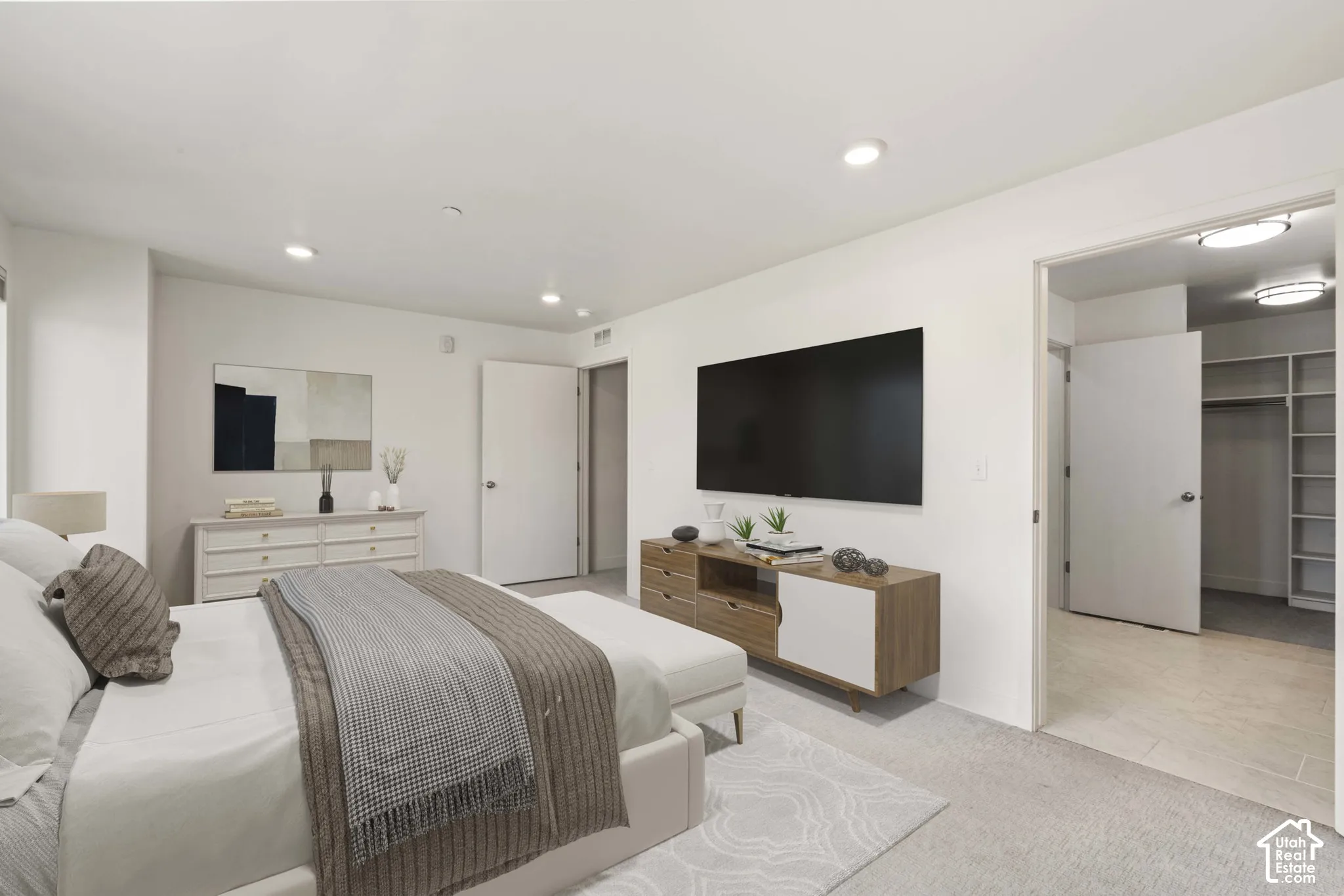 Spacious primary bedroom featuring an ensuite bathroom and large walk in closet