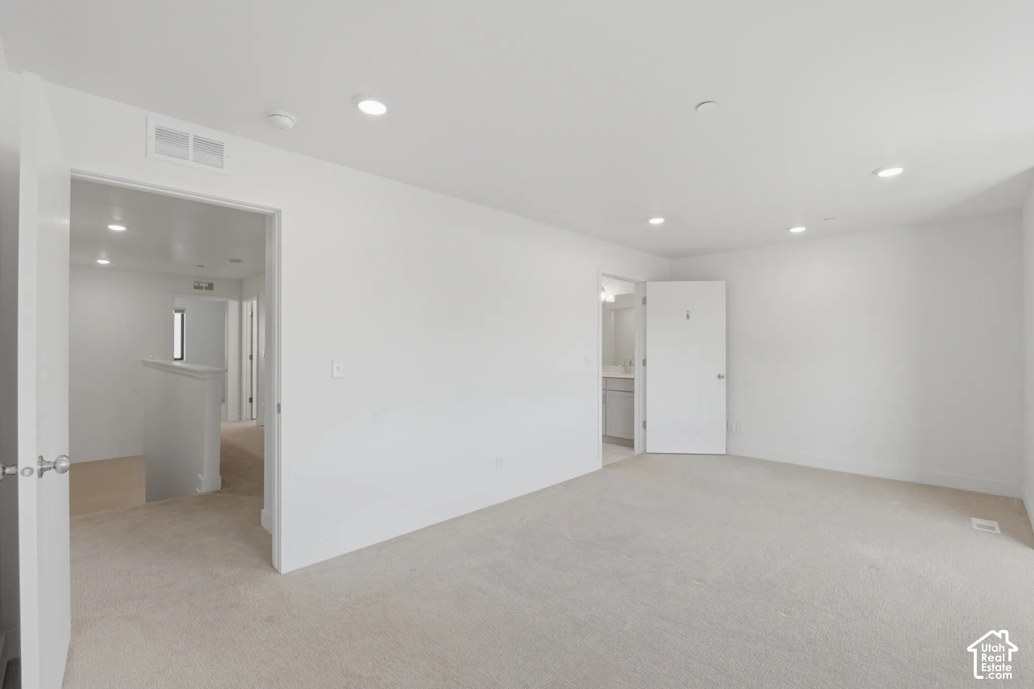 Spacious primary bedroom featuring an ensuite bathroom and large walk in closet