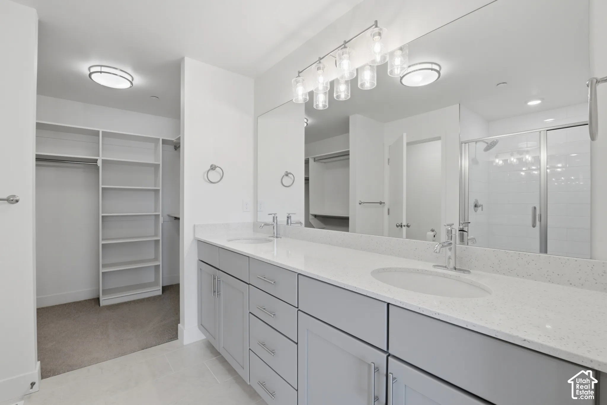 Primary ensuite bathroom with double vanity, grey cabinetry and white quartz countertops