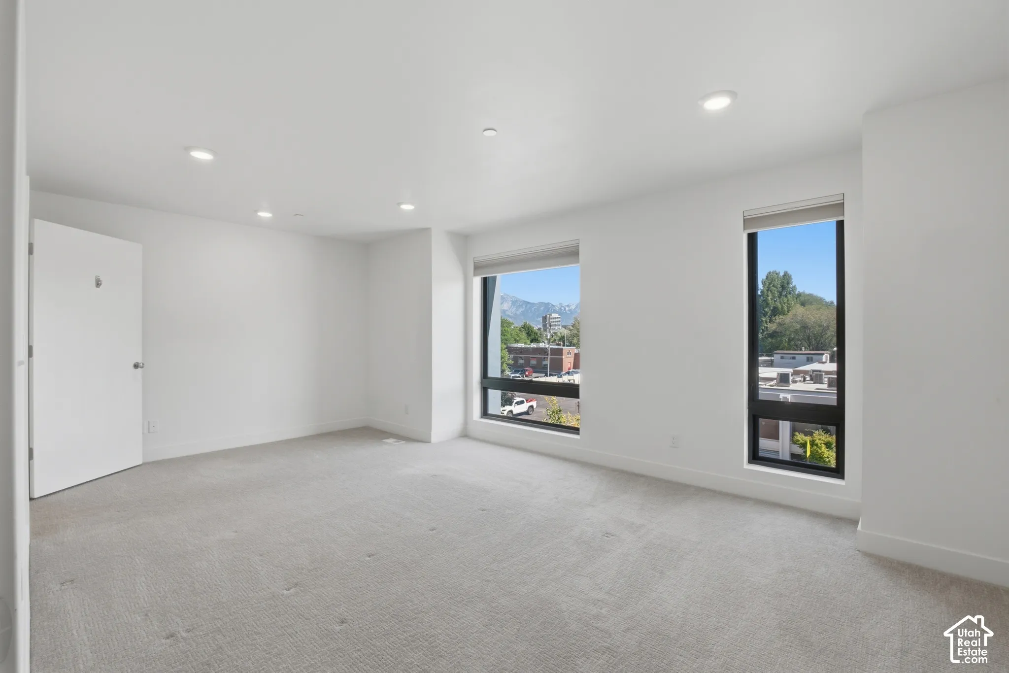 Spacious primary bedroom with large picture windows for lots of natural light