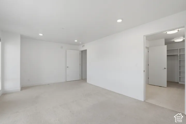 Spacious primary bedroom featuring an ensuite bathroom and large walk in closet