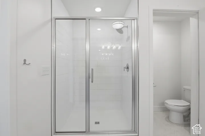Glass-enclosed shower with subway tile surround in primary bathroom