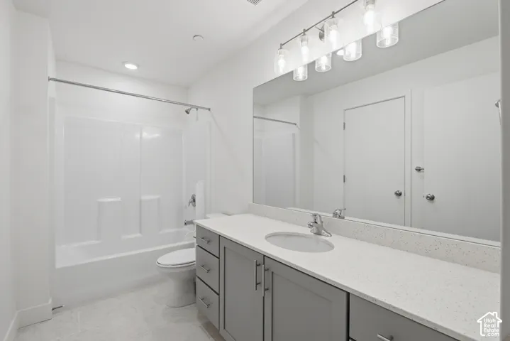 Second ensuite bathroom featuring a single vanity with white quartz countertops and a large mirror