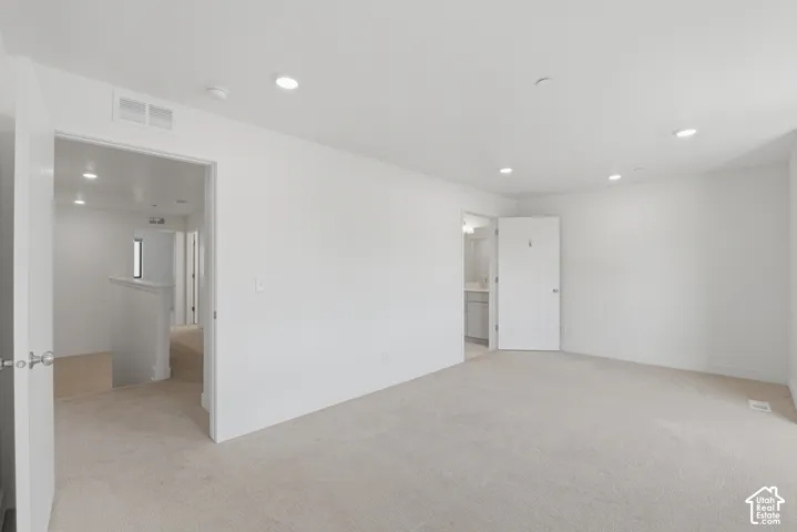 Spacious primary bedroom featuring an ensuite bathroom and large walk in closet