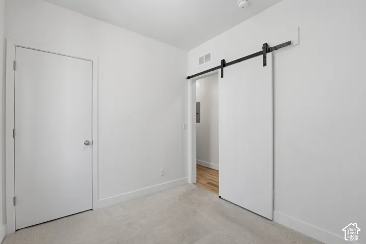 Bedroom on the main level featuring a sliding barn door - also makes a great office space!
