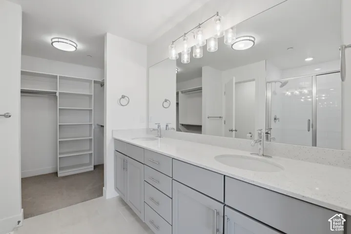 Primary ensuite bathroom with double vanity, grey cabinetry and white quartz countertops