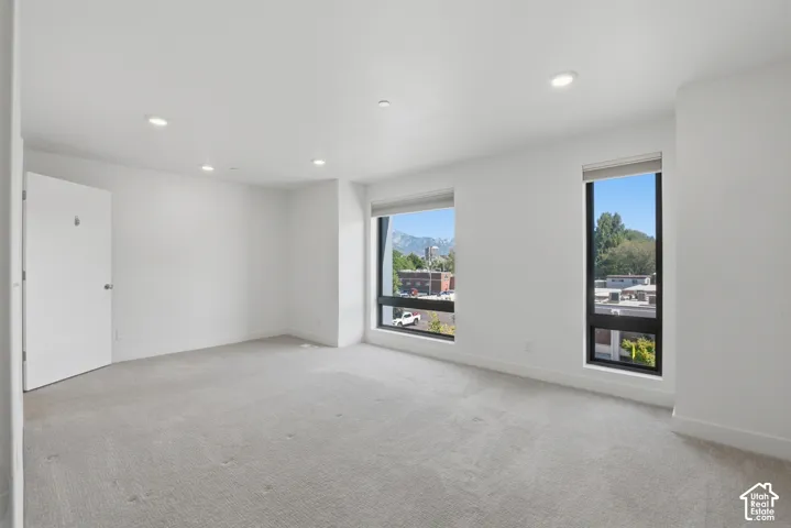 Spacious primary bedroom with large picture windows for lots of natural light