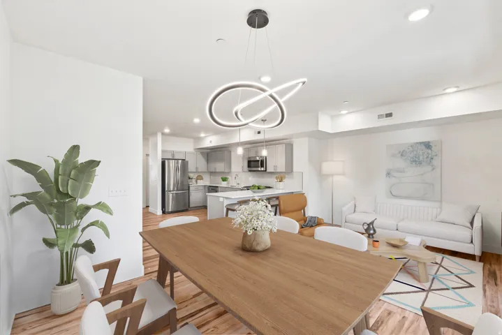 Open-concept living space featuring LVP flooring, recessed lighting, and a modern chandelier