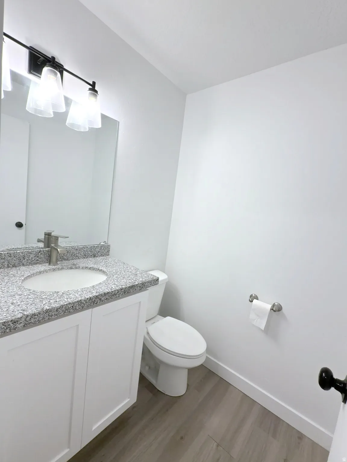 Bathroom featuring a white vanity with panel cabinetry, a granite-look countertop, and a circular undermount sink