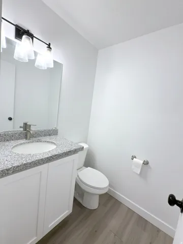 Bathroom featuring a white vanity with panel cabinetry, a granite-look countertop, and a circular undermount sink