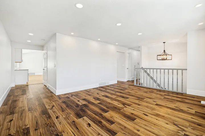 Spacious interior featuring wood-finish flooring, recessed lighting, and a contemporary chandelier
