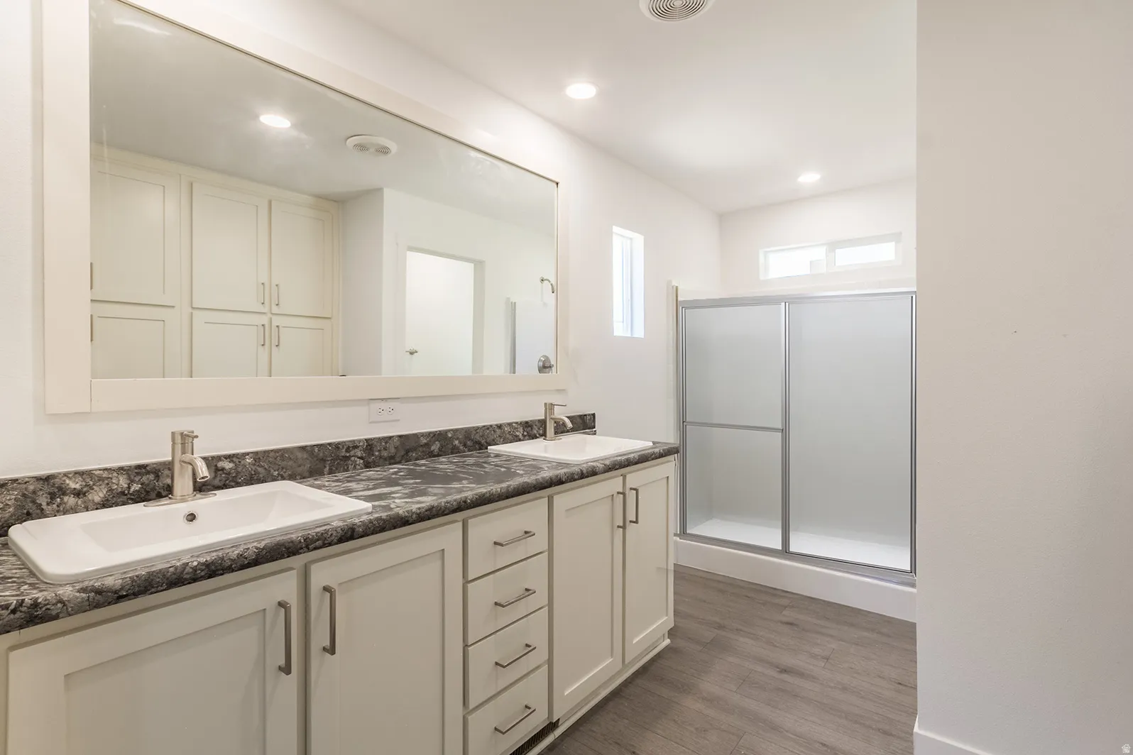 Dual vanity with rectangular sinks, a dark stone-finish countertop, and brushed nickel faucets