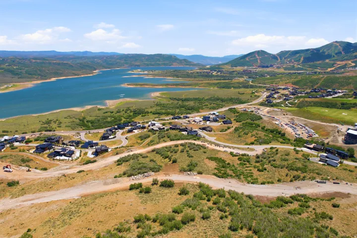 Expansive mountain landscape featuring a large body of water, residential development, and surrounding hills