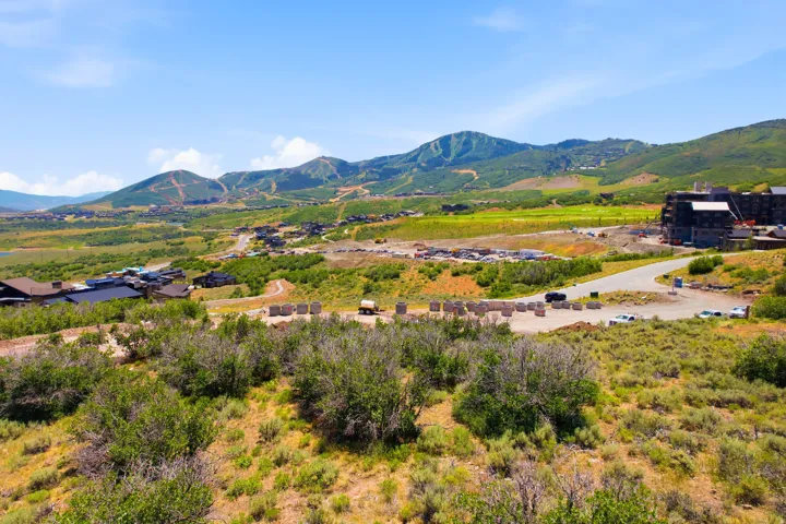 Expansive mountainous terrain with distant buildings and development