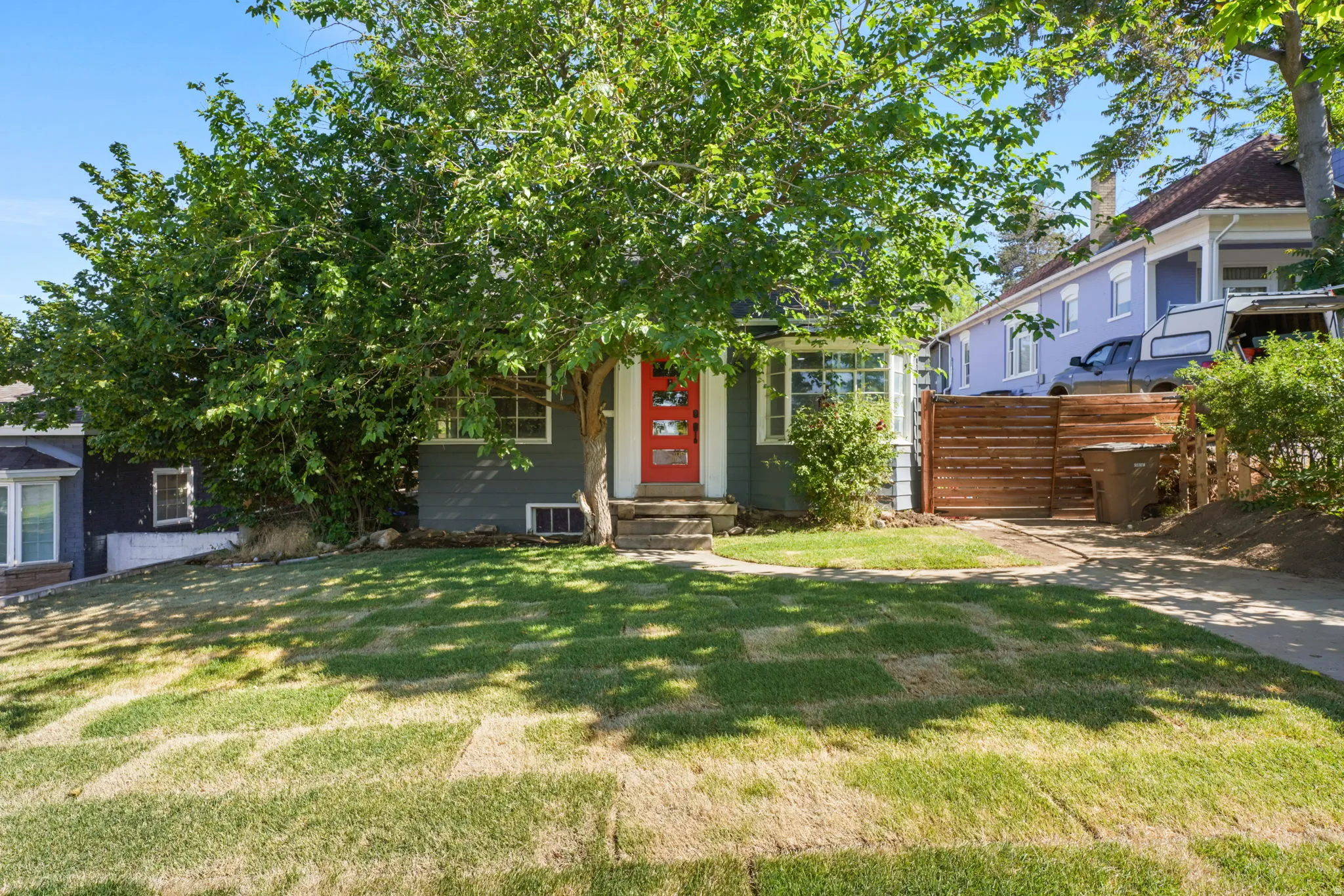 Gray exterior with a vibrant red entry door and white trim windows