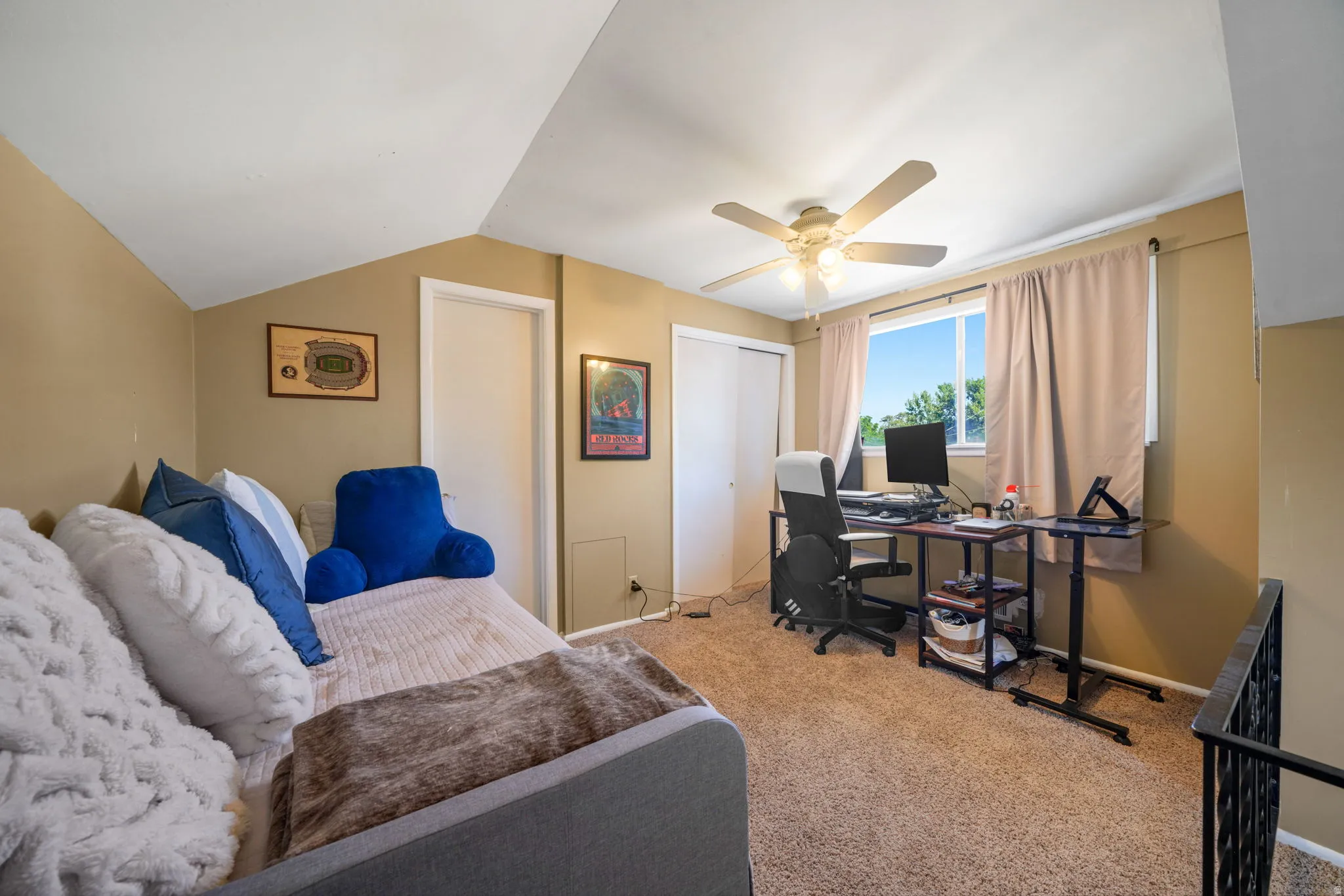 Carpeted room with a ceiling fan, a window, and two permanent doors