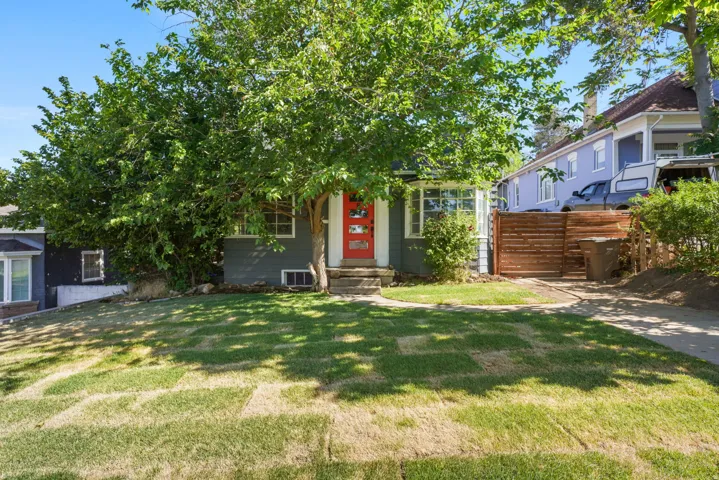 Gray exterior with a vibrant red entry door and white trim windows