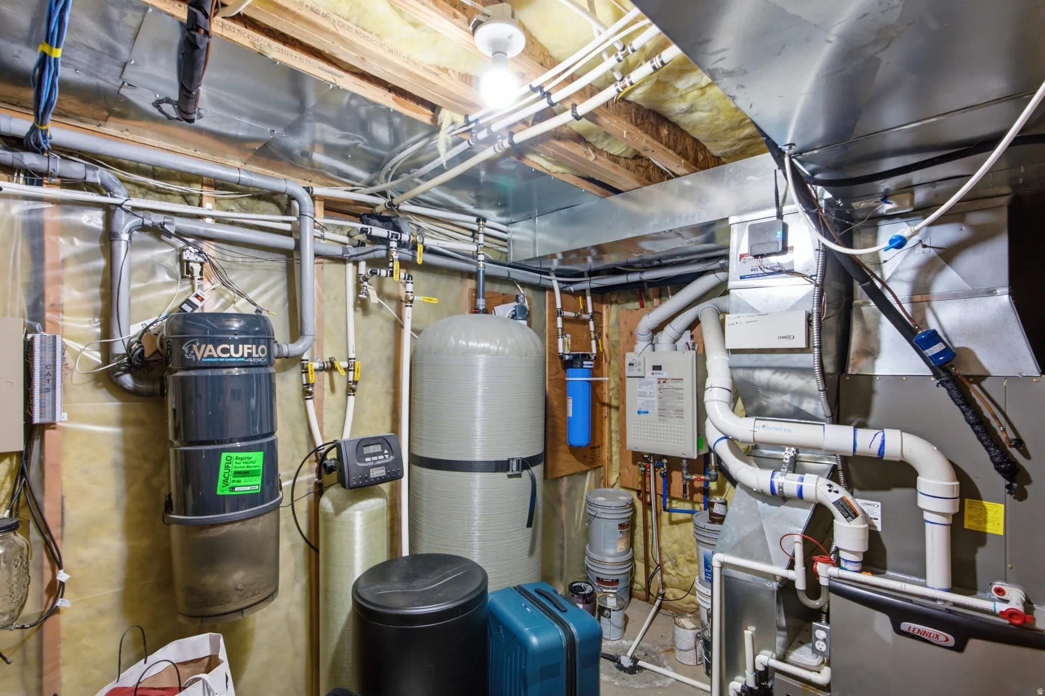 Utility space featuring a central vacuum system, water filtration unit, water softener, and HVAC system with exposed ductwork