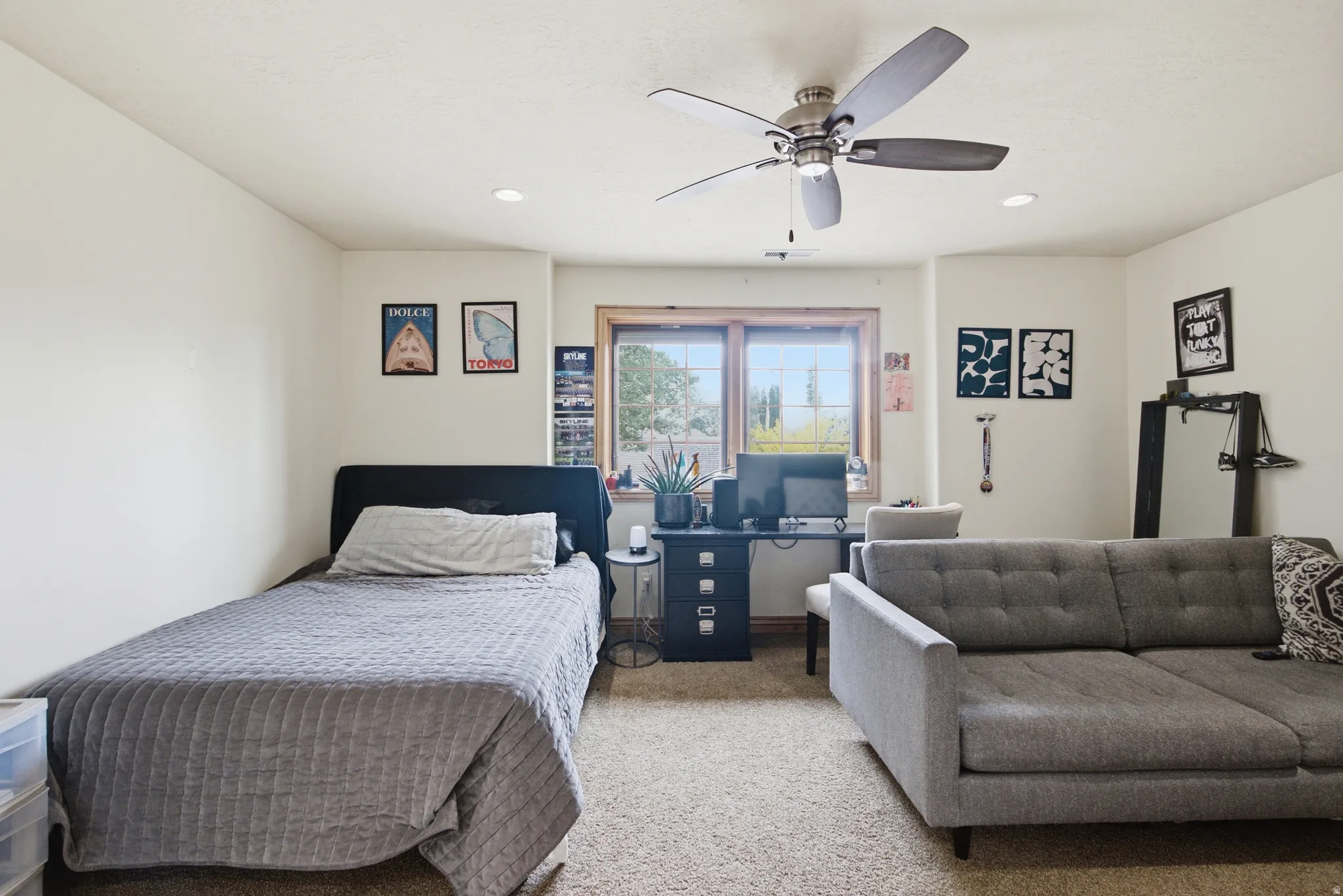 Carpeted room featuring a ceiling fan with integrated lighting, recessed lighting, and a double-pane window with wood trim