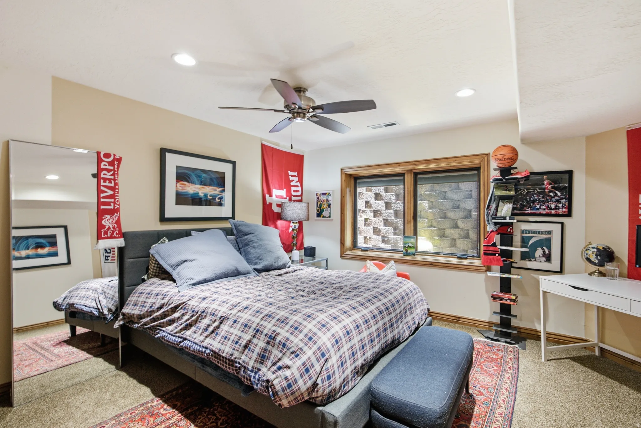 Recessed lighting and a ceiling fan illuminate this carpeted room