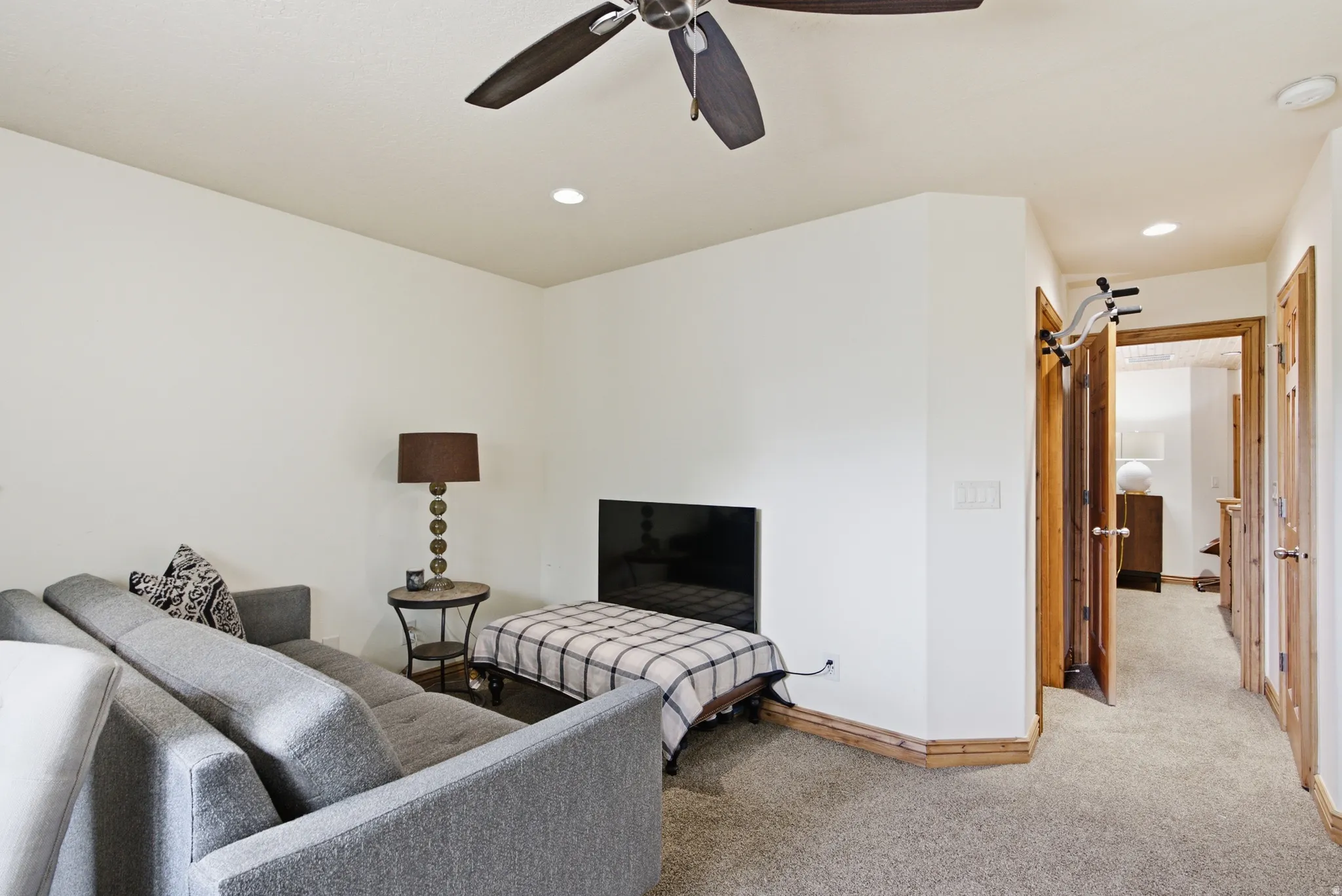 Carpeted interior space featuring white walls and recessed lighting