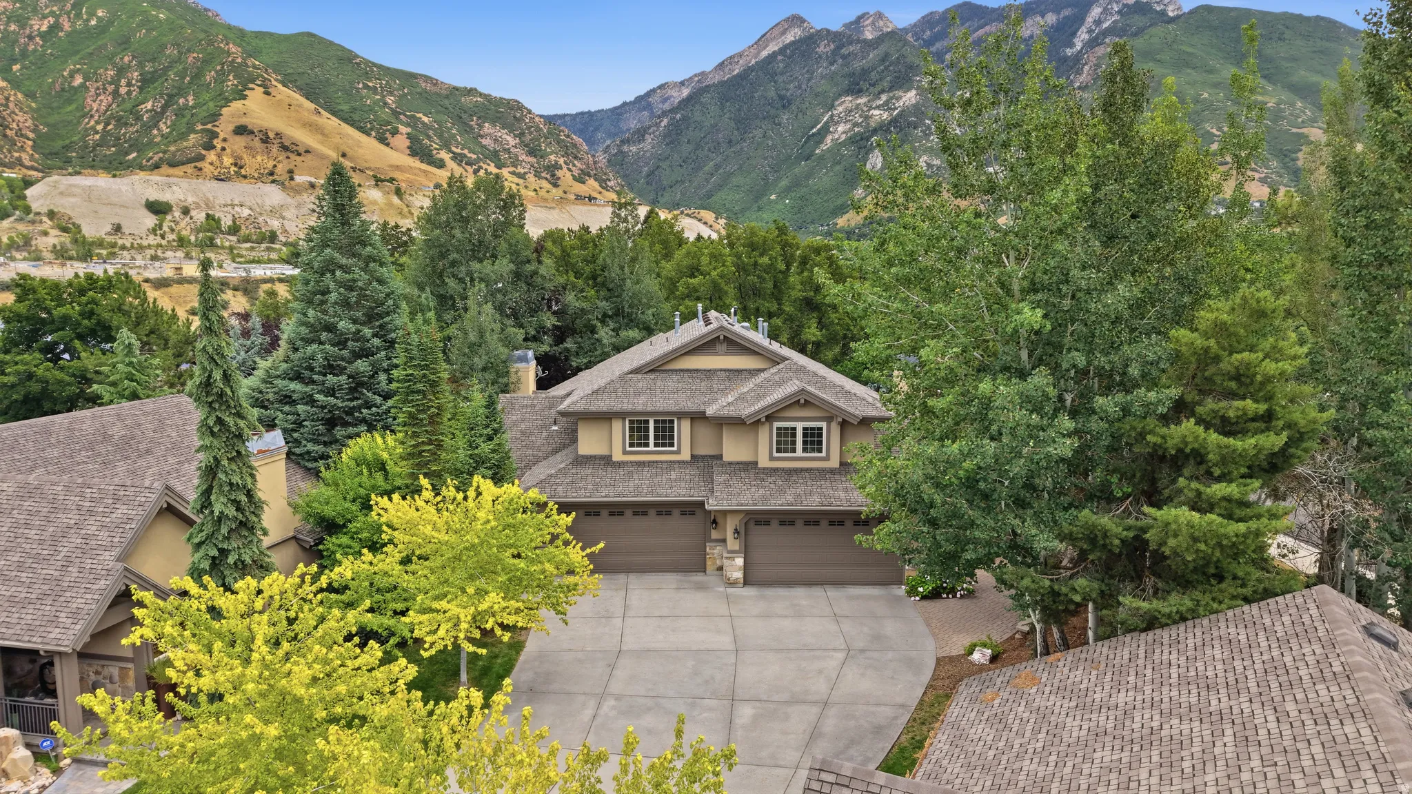Two-story residence featuring a multi-gabled roofline and a stone and stucco facade