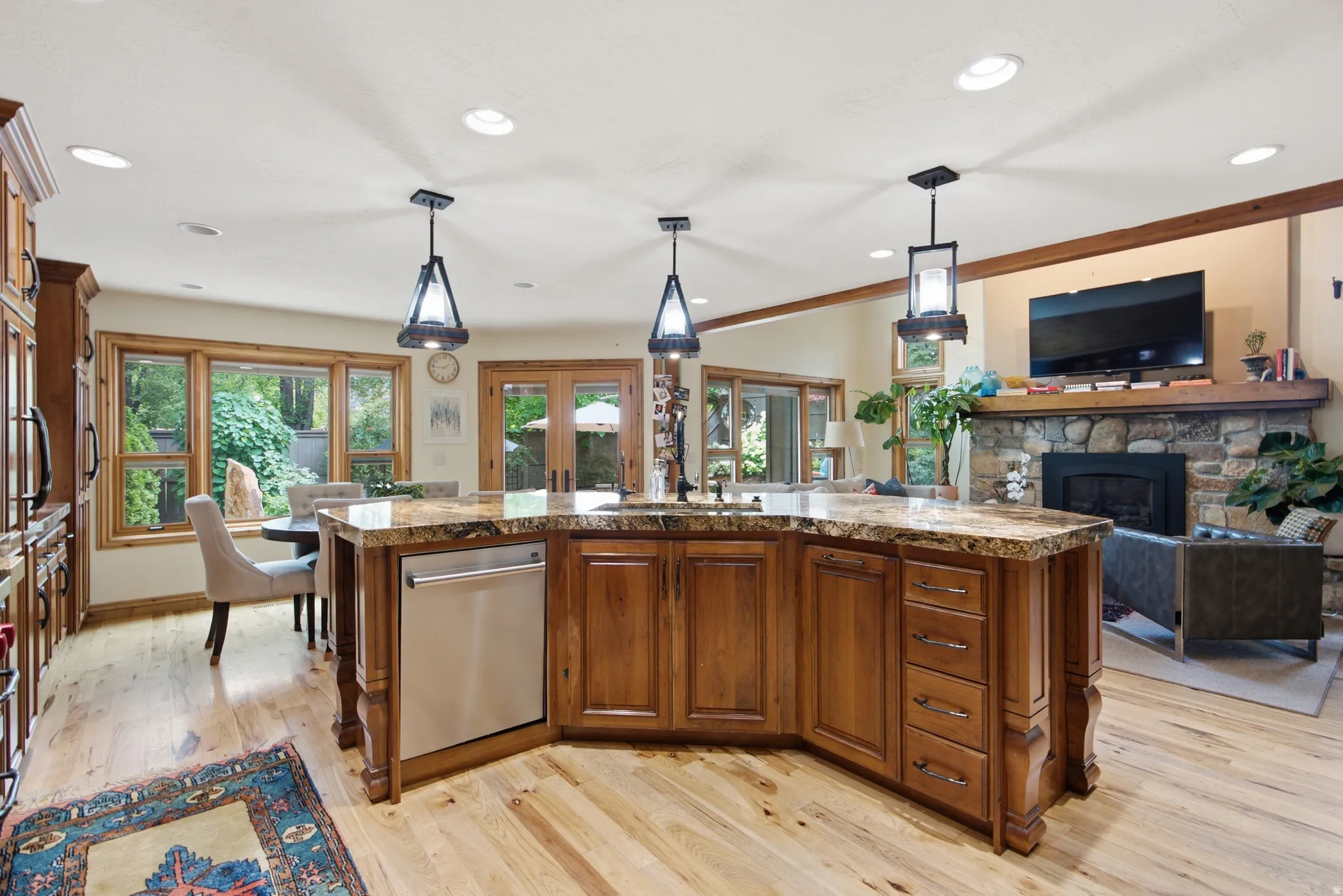Spacious kitchen island featuring a polished stone countertop and custom wood cabinetry